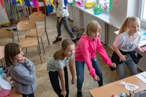 dziewczynki powtarzają kroki patrząc w komputer