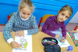 dwie dziewczynki kolorują malowanki